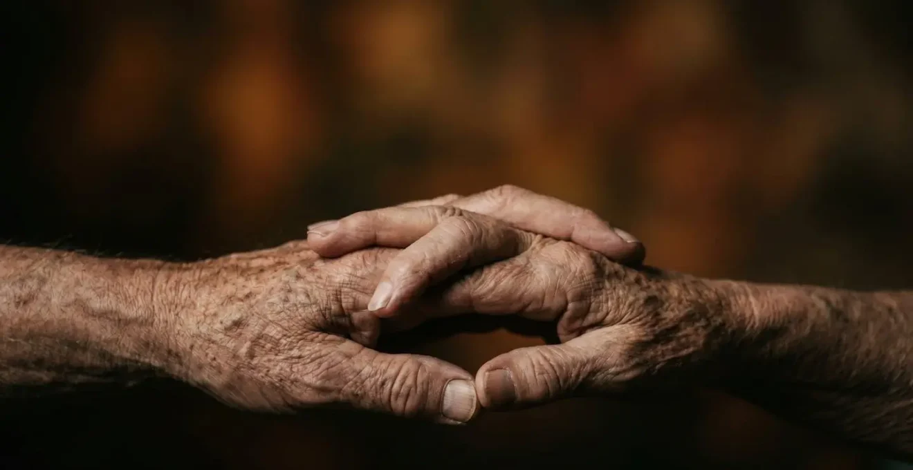Mains enlacées de couple senior symbolisant la protection mutuelle